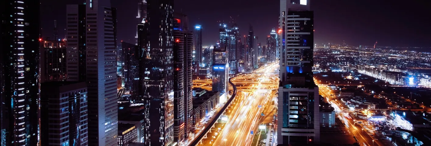 A view of a city at night from the top of a skyscraper.
